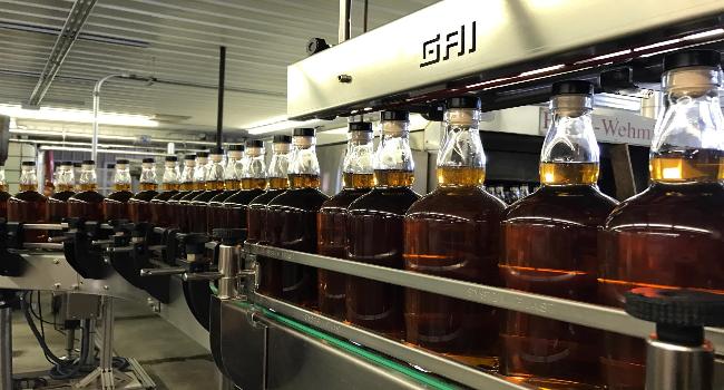 A line of whiskey bottles in a Distillary